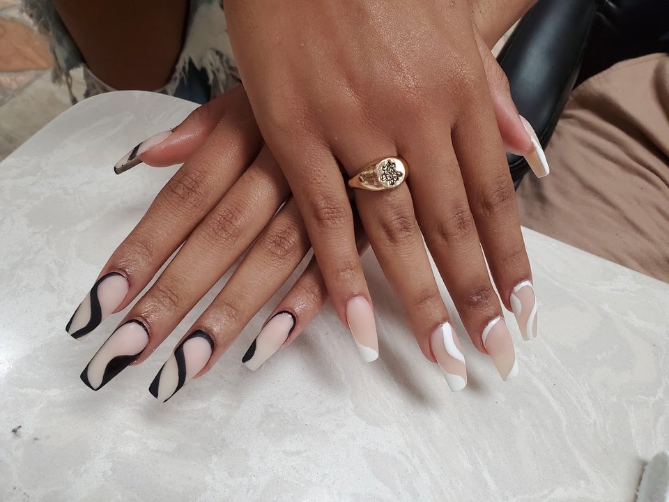 Nail technician painting a fresh manicure